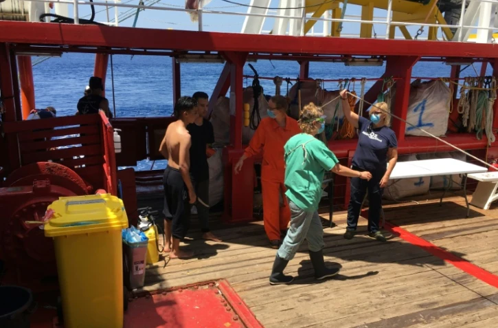 Des membres d'équipage participent au secours de deux migrants qui se sont jetés à l'eau depuis l'Ocean Viking, le 2 juillet 2020 en Méditerranée