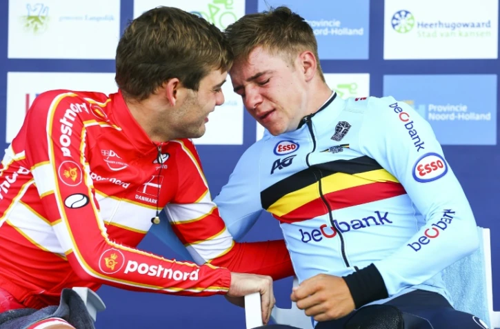 Le Danois Kasper Asgreen (g), médaille d'argent, félicite le prodige belge ému aux larmes Remco Evenepoel (d), nouveau champion d'Europe du contre-la-montre, le 8 août 2019 à Alkmaar (Pays-Bas) 
