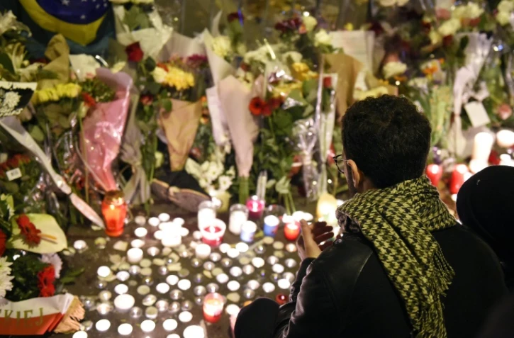 Un homme rend hommage aux victimes des attaques du Bataclan, le 14 novembre 2015 à Paris