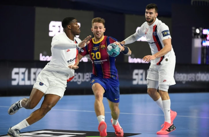 Le Barcelonais Aleix Gomez (centre) et les Parisiens Dylan Nahi (g) et Nedim Remili (d) lors de la demi-finale de la Ligue des champions de handball, le 28 décembre 2020 à Cologne, en Allemagne