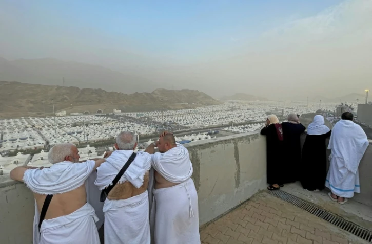 Des pèlerins musulmans syriens récitent des prières à leur arrivée à Mina, près de la ville sainte de La Mecque, le 26 juin 2023, lors du pèlerinage annuel du Hajj