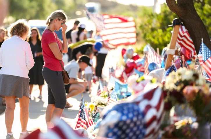 Des personnes se recueillent devant un mémorial improvisé en hommage à l'influenceur conservateur Charlie Kirk, le 14 septembre 2025 à Phoenix, en Arizona
