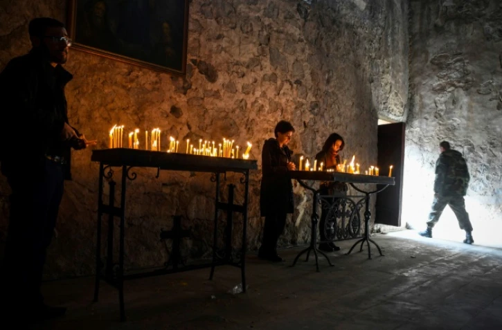 Des pèlerins arméniens allument des cierges pour la dernière fois le 12 novembre 2020 dans le monastère de Dadivank dans le district de Kaljabar, passé sous contrôle azerbaïdjanais, après l'accord mettant fin au conflit au Nagorny Karabakh