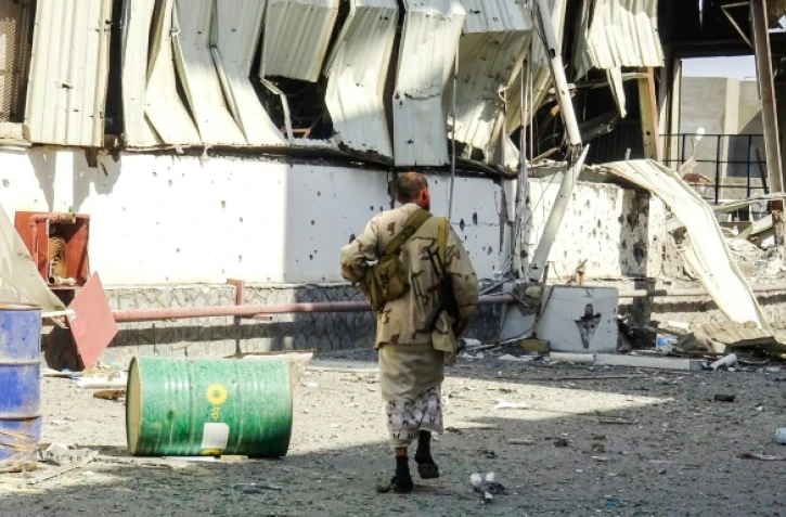 Un membre des forces progouvernementales yéménites dans une zone industrielle détruite par les combats le 19 novembre 2018 dans la ville portuaire de Hodeida cruciale pour l'arrivée de l'aide humanitaire