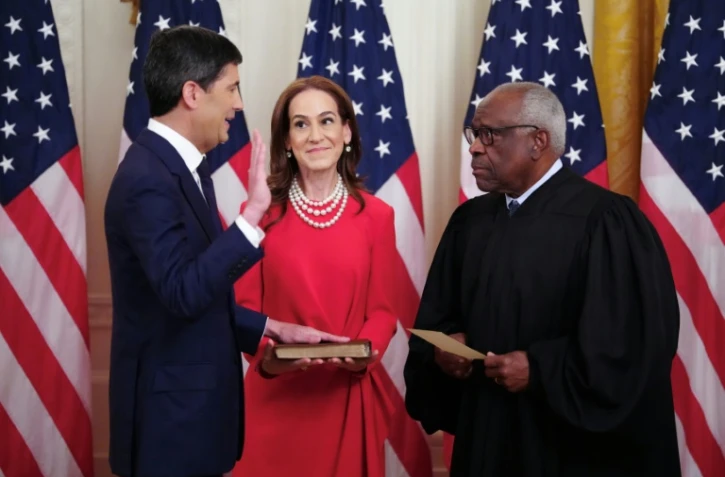 Le nouveau président de la Réserve fédérale (Fed), Kevin Warsh, accompagné de son épouse, Jane Lauder, prête serment devant le juge de la Cour suprême Clarence Thomas (d) à la Maison Blanche le 22 mai 2026 à Washington
