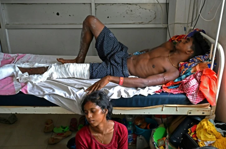 Blessé dans l'accident ferroviaire qui a frappé l'Inde, Gura Palai, est admis au Fakir Mohan Medical College and Hospital, et son épouse est assise à ses côtés, le 5 juin 2023. Des familles recherchaient toujours leurs proches disparus dans la catastrophe ferroviaire qui a fait au moins 288 morts en Inde