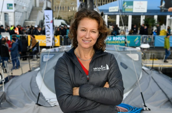 La navigatrice franco-allemande Isabelle Joschke pose à côté de son monocoque "Monin" au port de Saint-Malo, le 28 octobre 2018 