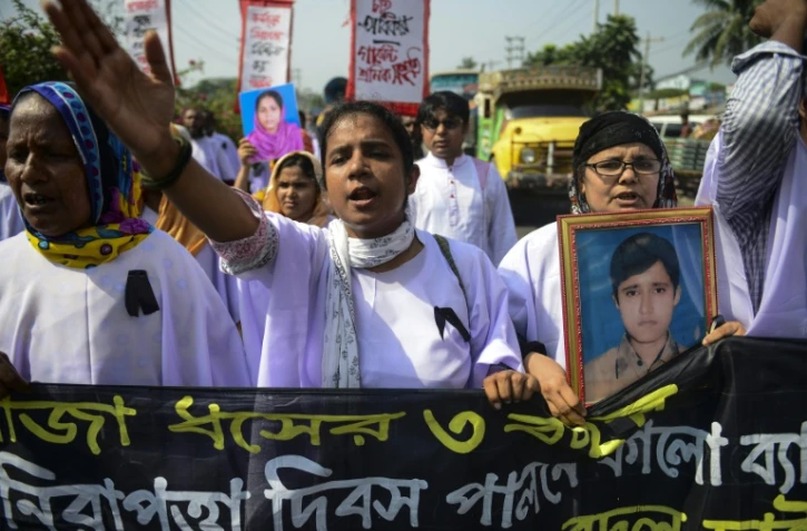 Des ouvriers du textile et des survivants du Rana Plaza défilent aux abords du lieu de la catastrophe qui a fait plus de 1.100 morts en 2013, le 24 avril 2016 à Savar dans la banlieue de Dacca