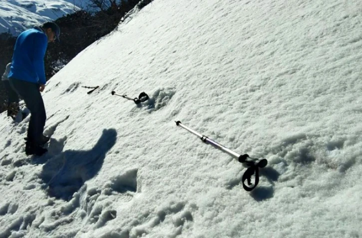 Des Indiens mesurent de larges empreintes dans la neige près du camp de base du Makalu dans l'Himalaya, sur une photo prise le 9 avril 2019 par l'armée indienne