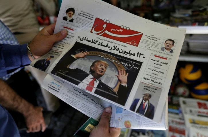 Un homme regarde la Une d'un quotidien iranien avec la photo du président américain Donald Trump, le 31 juillet 2018 à Téhéran