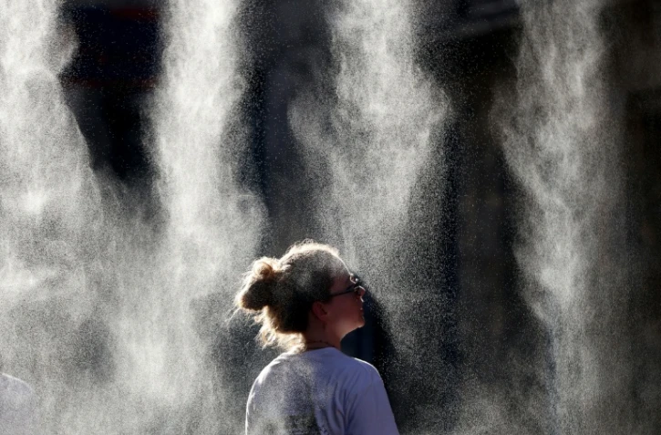 Une femme se rafraîchit sous un brumisateur à l'occasion de la Fête de la Musique à Bordeaux, en Gironde, pendant un épisode de canicule en France, le 21 juin 2026