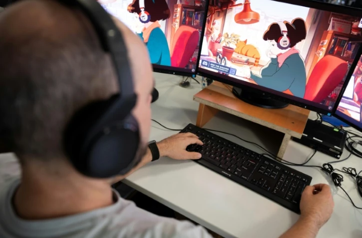 Un homme regarde sur son ordinateur la chaîne YouTube "LoFi Girl", produite par le Français Dim et illustrée par Juan Pablo Machado, le 17 septembre 2026 à Paris