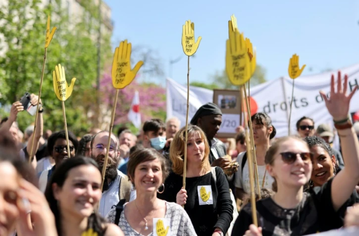 Manifestants brandissant des pancartes "Touche pas à mon pote", lors d'un rassemblement à Paris le 16 avril 2022 pour dénoncer l'extrême droite