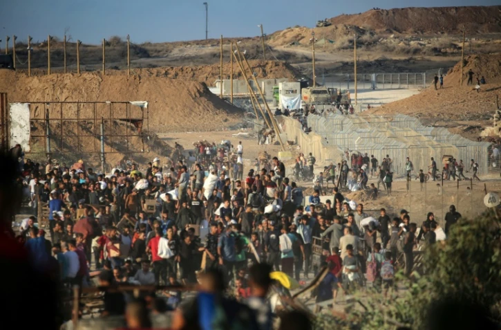 Des Palestiniens rassemblés à un point de distribution d'aide de la Fondation humanitaire de Gaza (GHF), près du camp de réfugiés de Nousseirat, dans le centre de la bande de Gaza, le 25 juin 2025