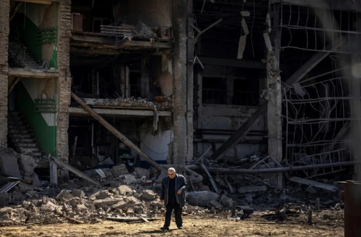 Un homme marche près d'un bâtiment à la façade effondrée du complexe militaro-industriel de la société Vizar, après que le site a été touché par des frappes russes nocturnes dans la banlieue de Kiev, le 15 avril 2022.