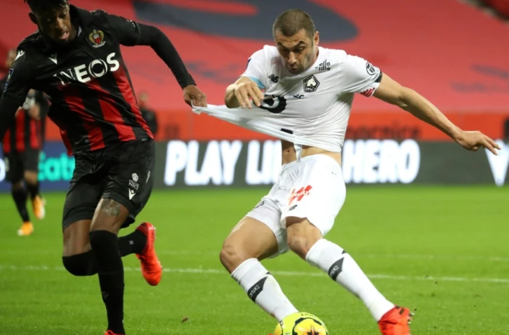 L'attaquant turc de Lille Burak Yilmaz (d) accroché par le défenseur brésilien de Nice Robson Bambu, le 25 octobre 2020 à Nice