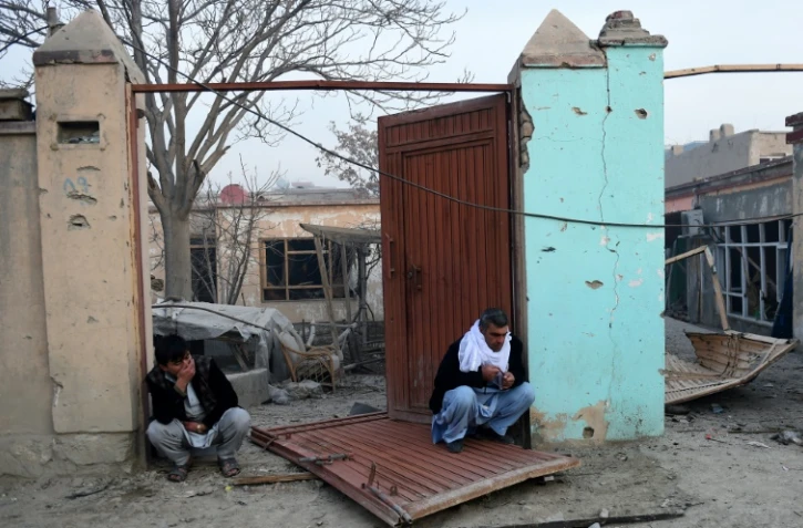 Des Afghans devant leur maison détruite à Kaboul, le 2 janvier 2016 conséquence de l'attentat contre le restaurant français