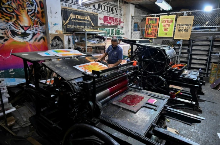 Jaime Garcia imprime des affiches sur la machine française Marinoni de 1870 à l'imprimerie La Linterna, le 4 mars 2021 à Cali, en Colombie