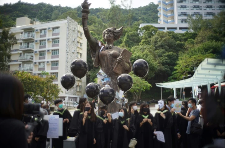 Etudiants manifestant devant la Déesse de la démocratie sur le campus de l'Université chinoise de Hong Kong, le 19 novembre 2021