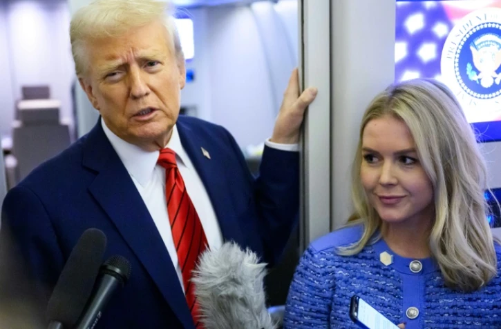Le président américain Donald Trump, aux côtés de la porte-parole de la Maison-Blanche Karoline Leavitt, s'adresse aux journalistes à bord d'Air Force One le 27 janvier 2025.