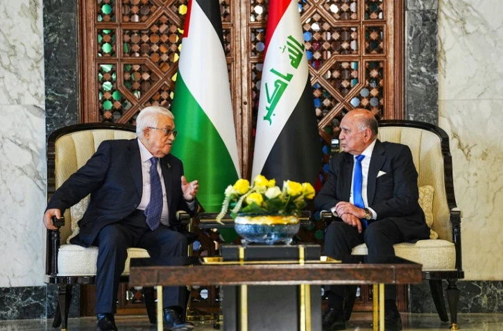 Le ministre irakien des Affaires étrangères Fouad Hussein (d) reçoit le président palestinien Mahmoud Abbas à l'aéroport de Bagdad avant le 34e sommet de la Ligue arabe, le 16 mai 2025
