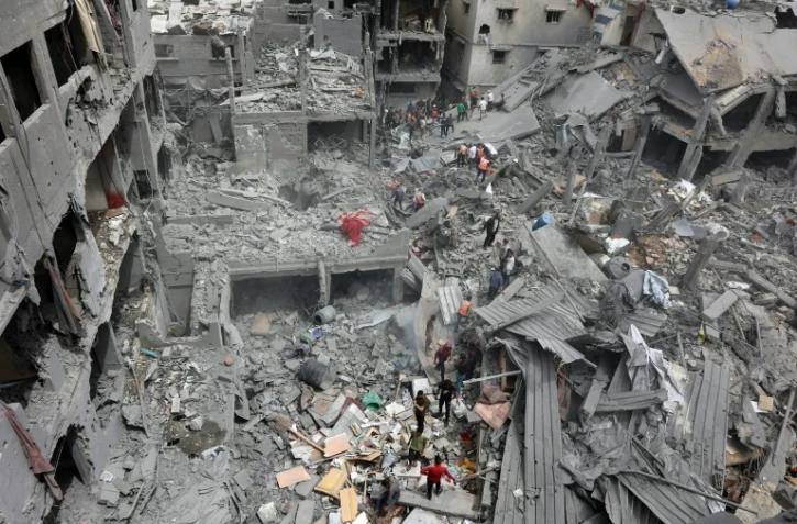 Des secouristes  palestiniens sur les décombres dans le quartier de Choujaïya à Gaza-ville après une frappe israélienne, le 9 avril 2025