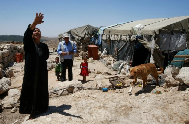Shafiq al-Tal (c) entouré de sa famille est devant sa tente dans le village palestinien de Khirbet Zannouta, près de Hébron, le 30 mai 2016 