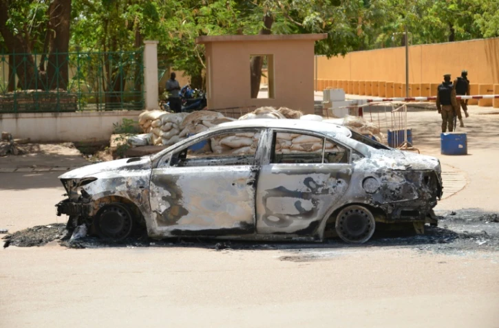 Une voiture incendiée devant l'ambassade de France à Ougadougou, le 3 mars 2018, au lendemain de la double attaque revendiquée par le Groupe pour le soutien de l'islam et des musulmans (GSIM).