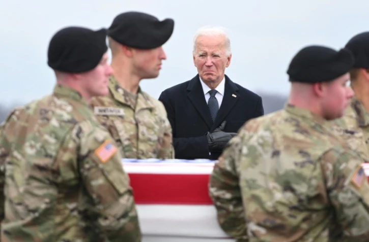 Le président américain Joe Biden (c) assiste au retour des dépouilles de trois soldats américains tués en Jordanie, le 2 février 2024 à la base aérienne de Dover, dans le Delaware