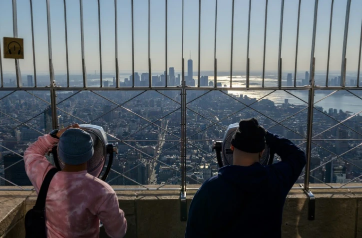 Des visiteurs admirent la vue depuis le 86ème étage de l'Empire State Building à New York, le 9 novembre 2021, au lendemain de la réouverture des frontières américaines aux voyageurs européens notamment