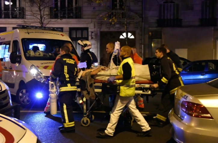 Une victime de l'attaque contre le Bataclan évacuée par les secours le 14 novembre 2015 à Paris