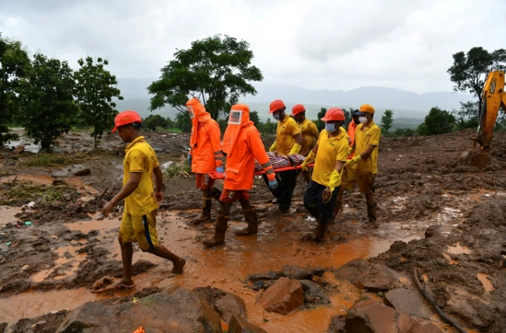 Les sauveteurs indiens portent le corps d'une victime des glissements de terrain à Taliye, le 25 juillet 2021
