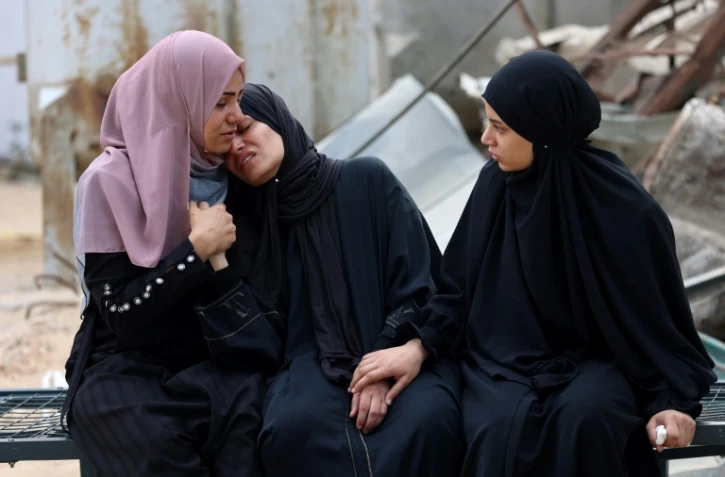 Des Palestiniennes la mort d'un proche tué près d'un centre de distribution d'aide dans la bande de Gaza, le 24 juin 2025