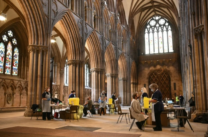Des habitants reçoivent une dose du vaccin AstraZeneca/Oxford contre le Covid-19 dans la cathédrale de Lichfield (centre de l'Angleterre), convertie en centre de vaccination, le 18 mars 2021