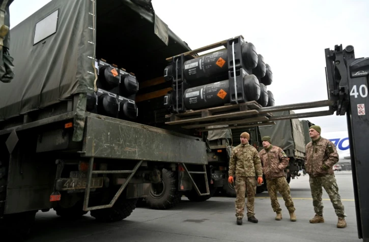 Des soldats ukrainiens chargent sur un camion des missiles FGM-148 Javelin anti-tanks livrés par avion par les Etats-Unis à l'aéroport Boryspil de Kiev, le 11 février 2022