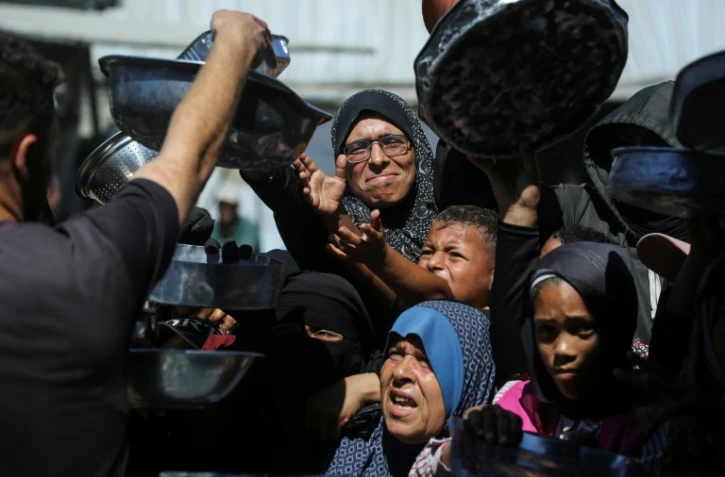 Nihaya Al-Masri (C), une Palestinienne déplacée lors d'une distribution alimentaire à Khan Younès, dans le sud du territoire palestinien, le 6 octobre 2026 
