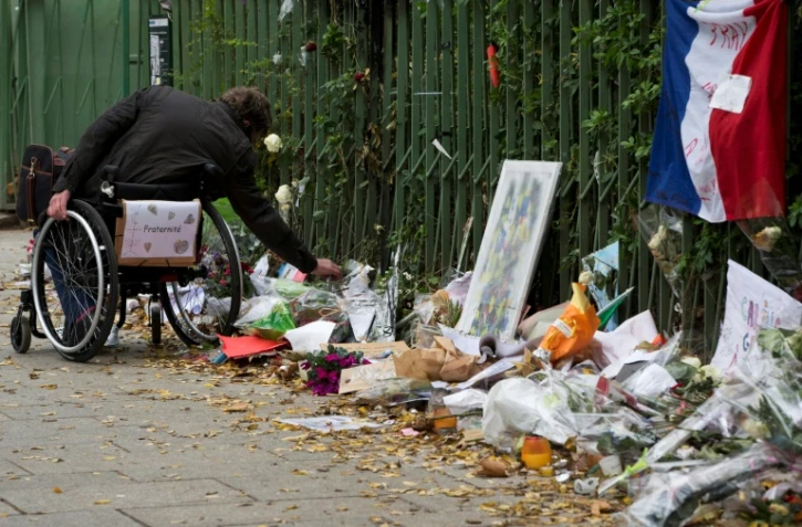 Un homme rend hommage aux victimes des attentas de Paris et Saint-Denis, devant le Bataclan, le 10 décembre 2015