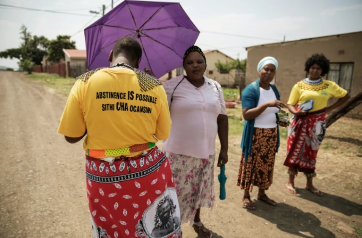 Bongiwe Sithole (g) et Thubelihle Dlodlo (d), bénéficiaires de la controversée "Bourse d'études pour les vierges", se promènent à Ezakheni, près de Ladysmith en Afrique du Sud, accompagnées de leurs matrones, le 16 février 2016