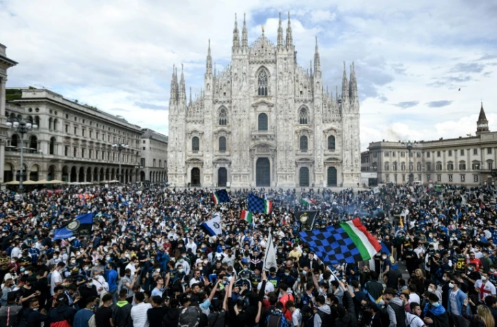 Des supporters de l'Inter Milan font la fête après que le club a été sacré champion d'Italie, sur la Piazza Duomo à Milan, le 2 mai 2021