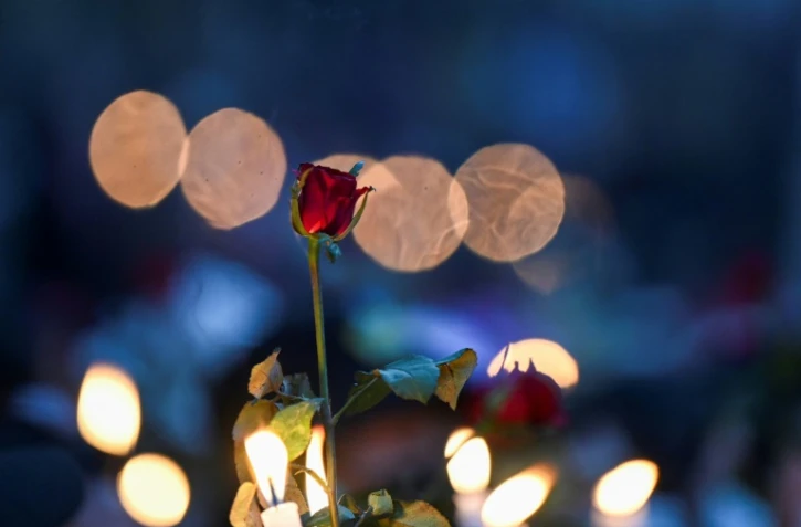 Bougies et roses brandies lors d'une veillée anti-junte militaire devant l'ambassade américaine à Rangoun, le 21 février 2021