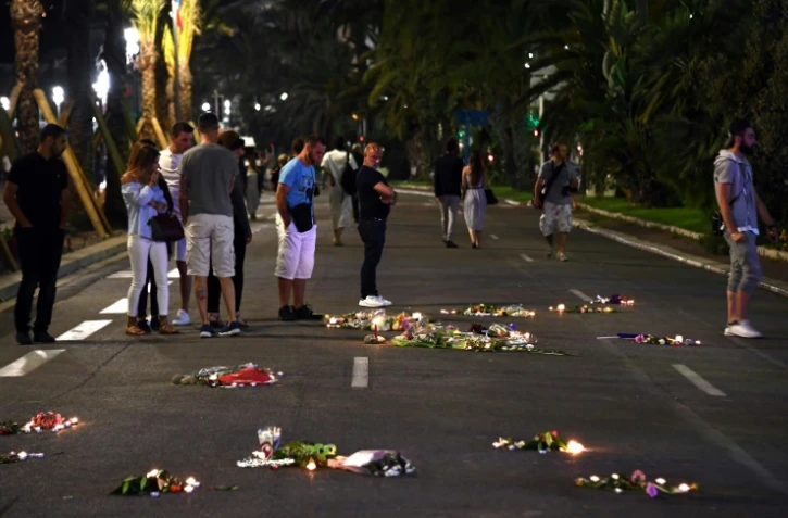 Photographie d'archive du 17 juillet 2016, montrant des bougies et des fleurs déposées en hommage aux victimes de l'attentat de Nice, survenu trois jours plus tôt