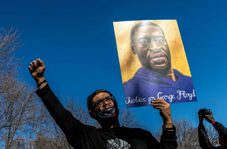 Un manifestant brandit un portrait de George Floyd à St. Paul, ville jumelle de Minneapolis, le 6 mars 2021