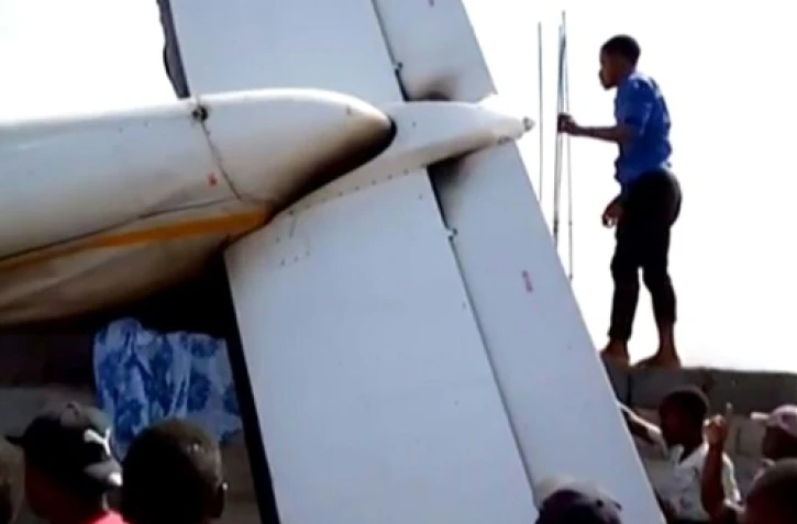 Des habitants de Goma, dans l'est de la RDC, s'affairent autour de l'épave d'un petit avion qui s'est écrasé sur des maisons le 24 novembre 2019, faisant 23 morts selon les secours.
