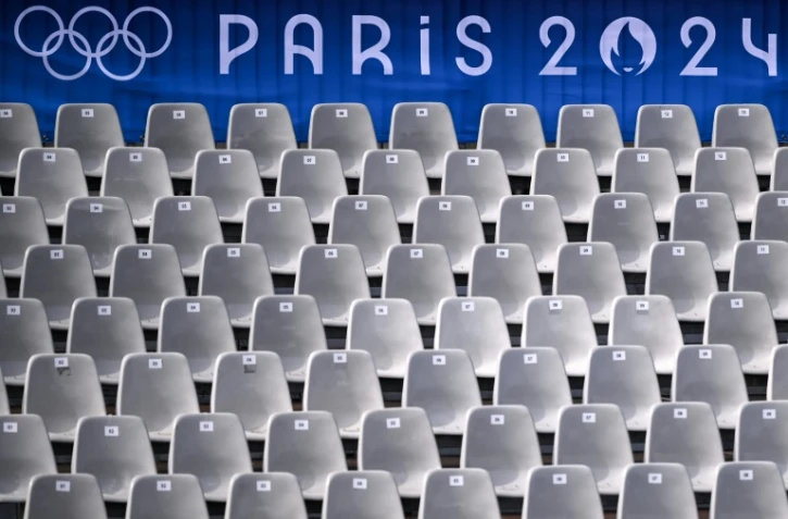 Une bannière des Jeux olympiques de Paris surplombe une tribune bordant la Seine pour la cérémonie d'ouverture des JO-2024, le 20 juillet 2024 à Paris