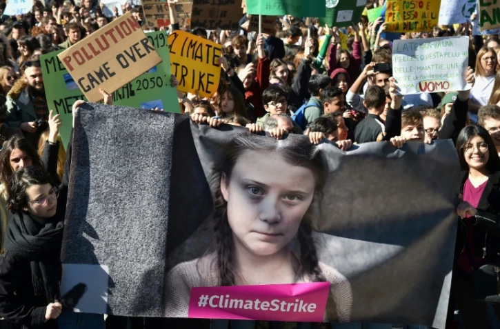 Des manifestants tiennent une banderole avec le portrait de l'activiste environnementale Greta Thunberg, Ă Rome le 15 mars 2019