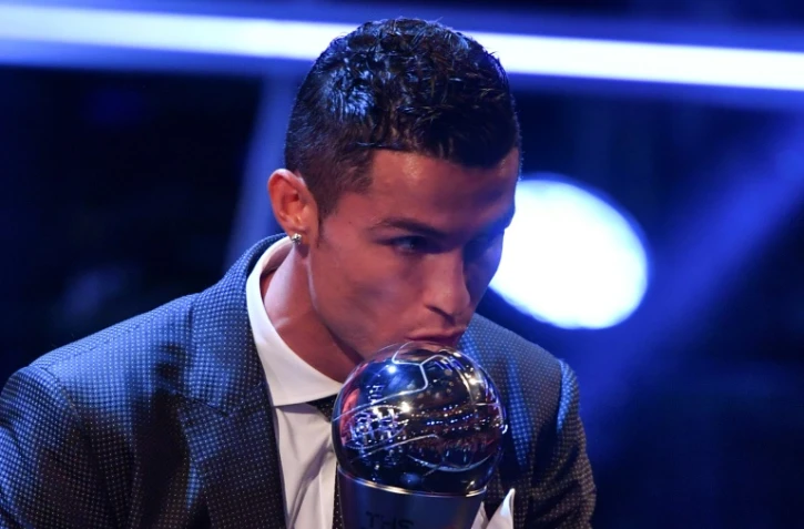 L'attaquant du Real Madrid et du Portugal Cristiano Ronaldo embrasse le trophée après avoir reçu le prix du meilleur joueur Fifa de l'année, le 23 octobre 2017 à Londres