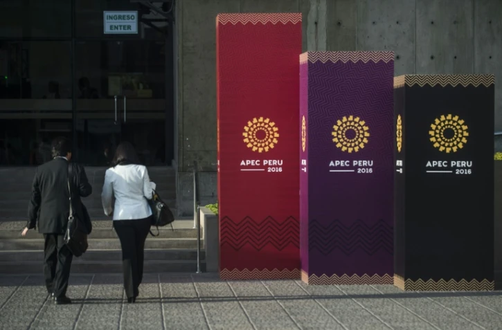 Des personnes arrivent sur le lieu où se déroule la réunion annuelle de l'Apec