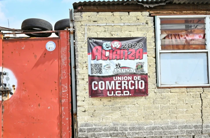 Une affiche sur le mur d'une entreprise indique un signe d'affiliation payante à des groupes qui garantissent la sécurité contre l'extorsion à Ecatepec, dans l'État de Mexico, le 2 octobre 2025