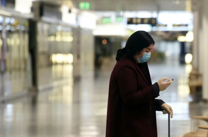 Une personne porte masque et gants dans un terminal vide à l'aéroport Franz-Josef-Strauss à Munich, le 28 avril 2020
