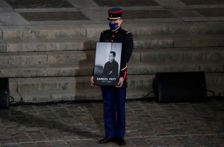 Un garde républicain tient le portrait de l'enseignant assassiné Samuel Paty lors de l'hommage national lui étant rendu le 21 octobre 2020 à la Sorbonne à Paris 